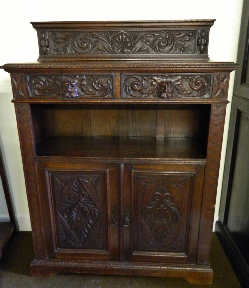 carved oak green man cupboard